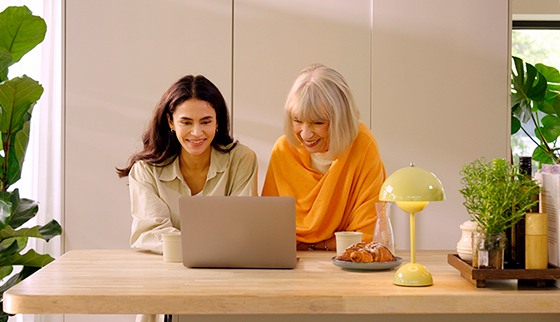 two women using a laptop