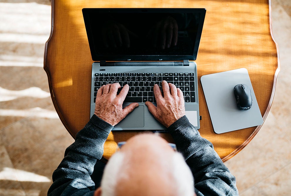 A senior man using a laptop