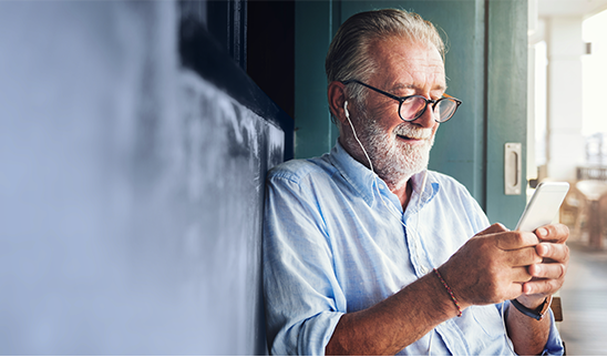 man with glasses scrolling on a smartphone