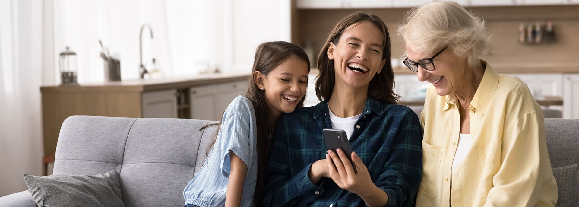 two women and a girl looking on a smartphone