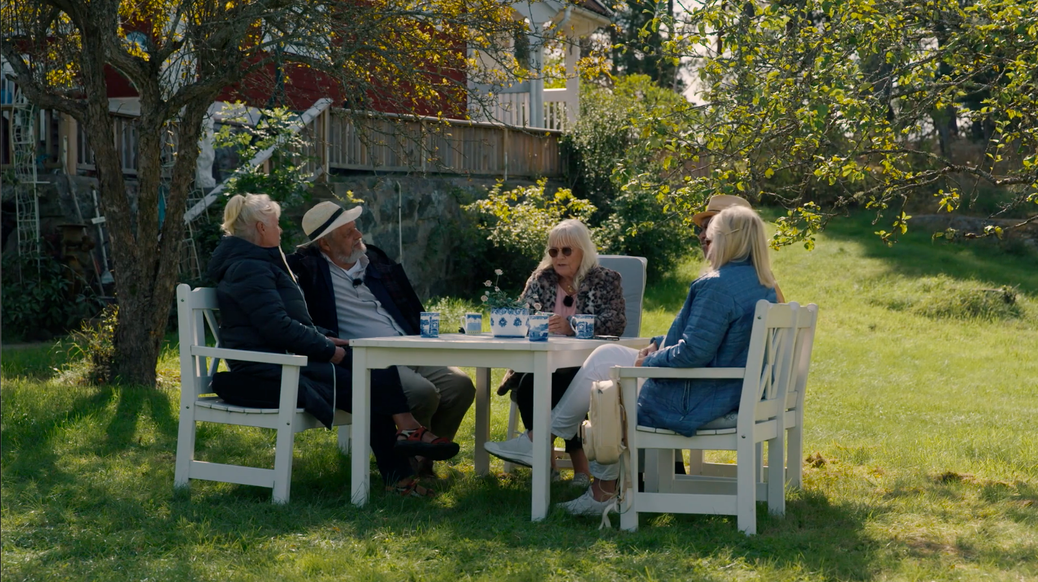 four people sitting in a garden