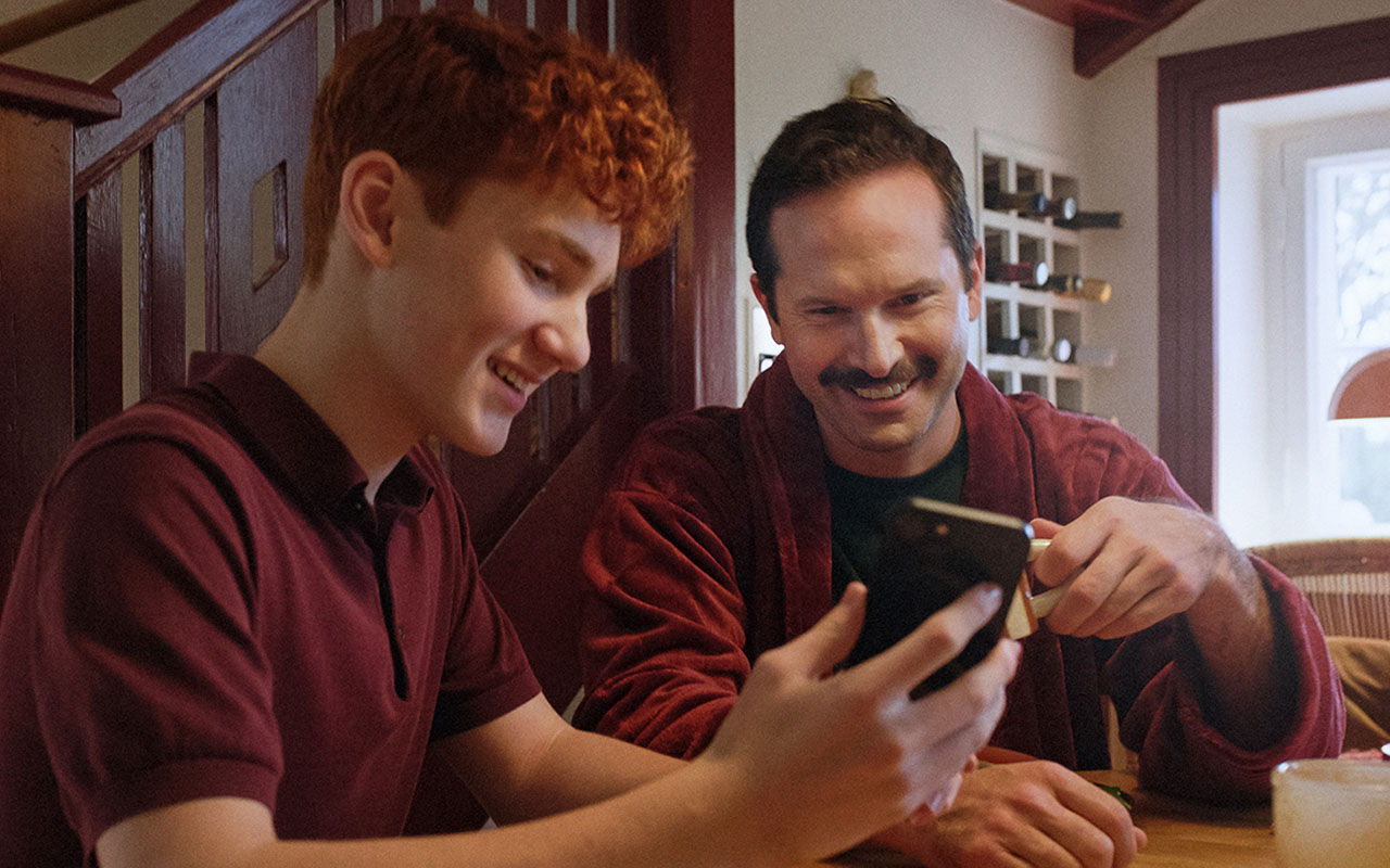 two men looking at a smartphone